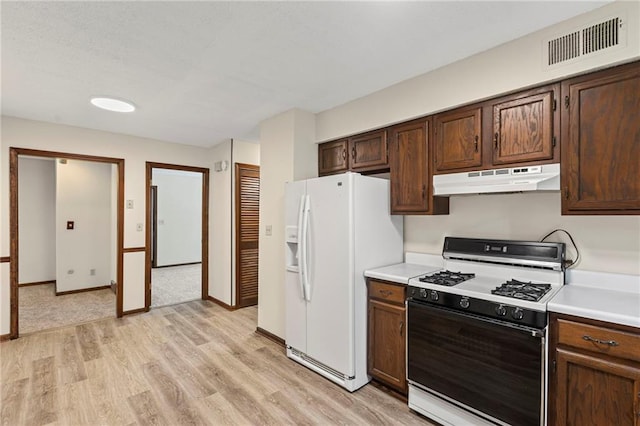 10131 W 84th St, Overland Park, KS 66212 - kitchen with range with gas cooktop, under cabinet range hood, white fridge with ice dispenser, light wood-style flooring, and light countertops