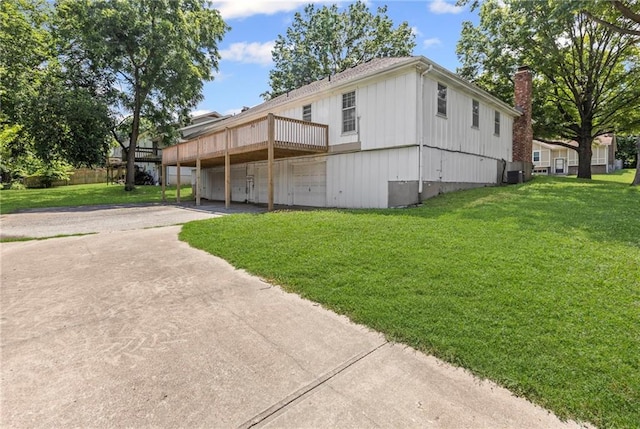 10131 W 84th St, Overland Park, KS 66212 - view of front of home with concrete driveway, a front lawn, a deck, a carport, and a chimney