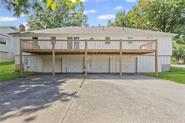 10131 W 84th St, Overland Park, KS 66212 - back of property with asphalt driveway, a deck, a chimney, and a garage