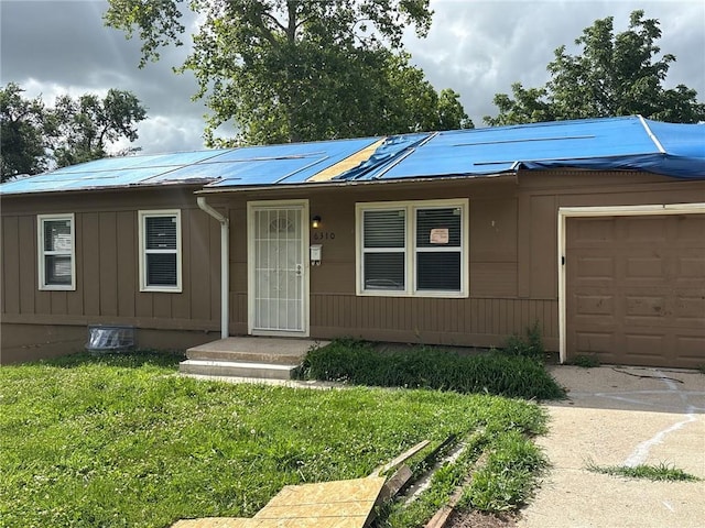 6310 E 153rd St, Grandview, MO 64030 - view of front facade with a garage, a metal roof, and a front lawn
