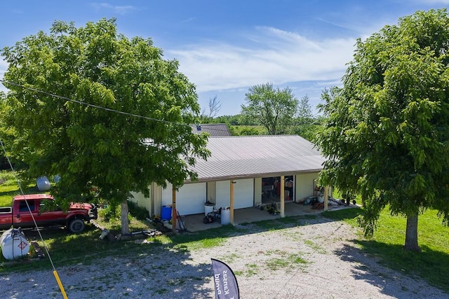 24305 Loring Rd, Lawrence, KS 66044 - view of front of home with driveway, covered porch, a metal roof, and a garage