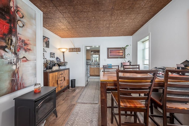 24305 Loring Rd, Lawrence, KS 66044 - dining room with ornamental molding, a wood stove, wood finished floors, and an ornate ceiling