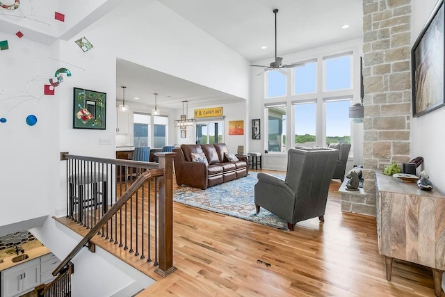 8319 Pickering St, Lenexa, KS 66227 - living area with a ceiling fan, light wood-type flooring, a towering ceiling, a chandelier, and recessed lighting