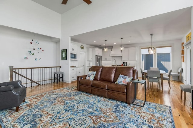 8319 Pickering St, Lenexa, KS 66227 - living room featuring light wood-style floors, a ceiling fan, recessed lighting, and a high ceiling