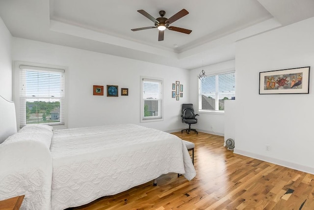 8319 Pickering St, Lenexa, KS 66227 - bedroom with a raised ceiling, light wood-style flooring, and a ceiling fan