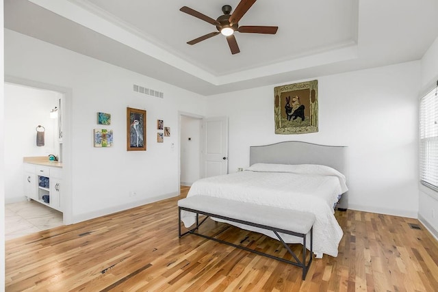 8319 Pickering St, Lenexa, KS 66227 - bedroom featuring a tray ceiling, light wood-type flooring, ceiling fan, and ensuite bath