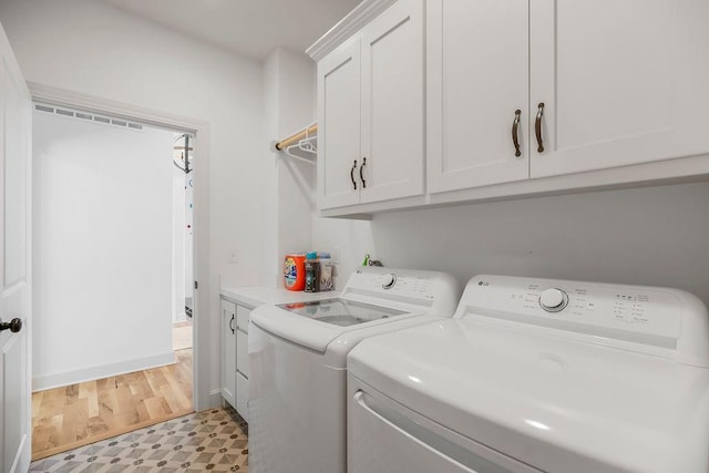 8319 Pickering St, Lenexa, KS 66227 - laundry room with washer and clothes dryer, cabinet space, and light flooring