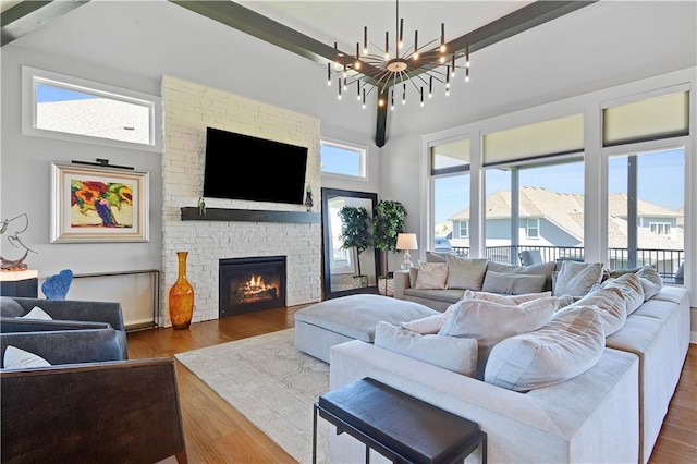11126 W 172nd Ter, Overland Park, KS 66221 - living area with a chandelier, wood finished floors, a stone fireplace, and a towering ceiling