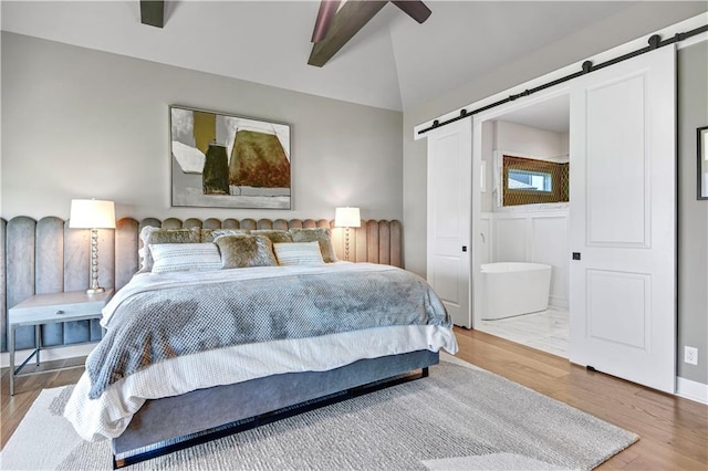 11126 W 172nd Ter, Overland Park, KS 66221 - bedroom with a barn door, wood finished floors, ensuite bathroom, and a ceiling fan