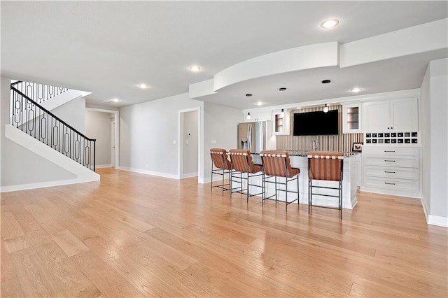 11126 W 172nd Ter, Overland Park, KS 66221 - kitchen featuring a breakfast bar area, white cabinetry, a kitchen island, light wood-style floors, and recessed lighting