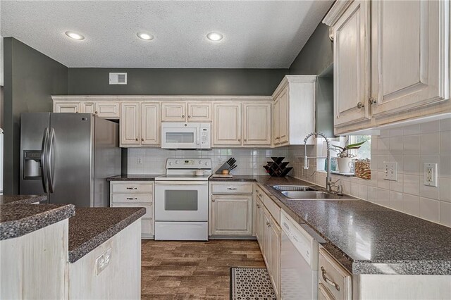 1210 NW Persimmon Dr, Grain Valley, MO 64029 - kitchen with white appliances, dark countertops, dark wood-style flooring, decorative backsplash, and a textured ceiling
