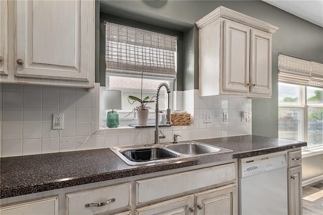 1210 NW Persimmon Dr, Grain Valley, MO 64029 - kitchen featuring dishwasher, dark countertops, and backsplash