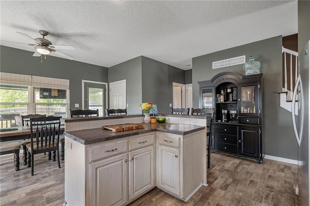 1210 NW Persimmon Dr, Grain Valley, MO 64029 - kitchen featuring ceiling fan, light wood-type flooring, a textured ceiling, a kitchen island, and freestanding refrigerator