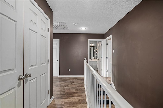 1210 NW Persimmon Dr, Grain Valley, MO 64029 - hallway featuring wood finished floors, a textured ceiling, and recessed lighting