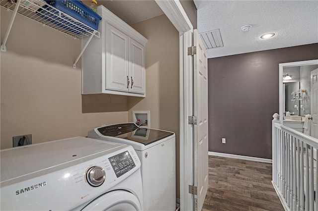 1210 NW Persimmon Dr, Grain Valley, MO 64029 - washroom with washing machine and clothes dryer, cabinet space, dark wood-style floors, and a textured ceiling