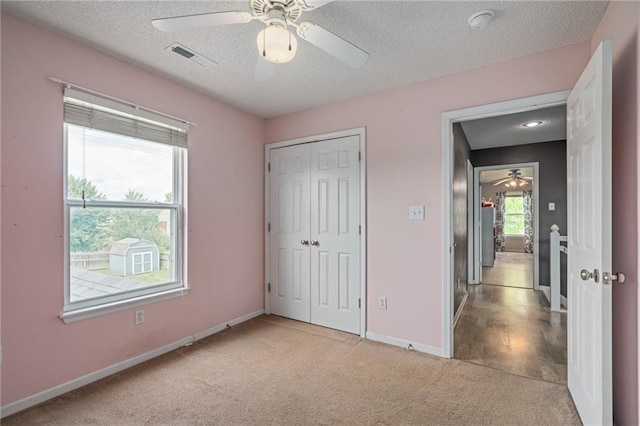 1210 NW Persimmon Dr, Grain Valley, MO 64029 - unfurnished bedroom featuring carpet floors, a textured ceiling, a closet, and a ceiling fan
