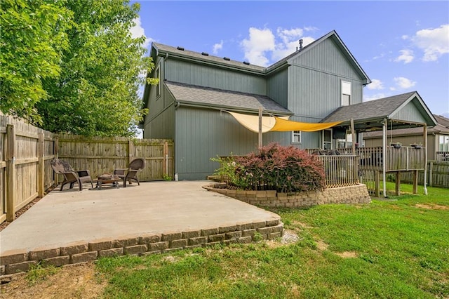 1210 NW Persimmon Dr, Grain Valley, MO 64029 - rear view of property featuring a patio area, a fenced backyard, and an outdoor fire pit