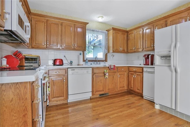 3038 Weaver School Rd, Odessa, MO 64076 - kitchen with white appliances, light wood-style floors, light countertops, and brown cabinets