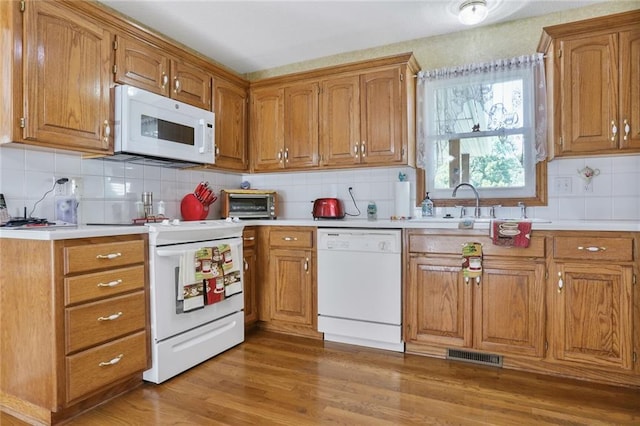 3038 Weaver School Rd, Odessa, MO 64076 - kitchen with white appliances, brown cabinets, light countertops, and tasteful backsplash