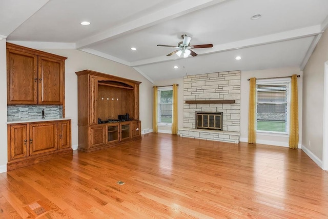 7718 W 100th St, Overland Park, KS 66212 - unfurnished living room with light wood-style flooring, a ceiling fan, and a fireplace