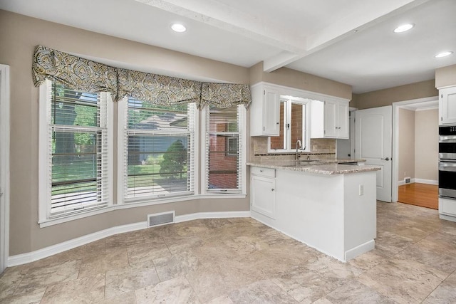 7718 W 100th St, Overland Park, KS 66212 - kitchen featuring white cabinets, a peninsula, backsplash, light stone countertops, and recessed lighting
