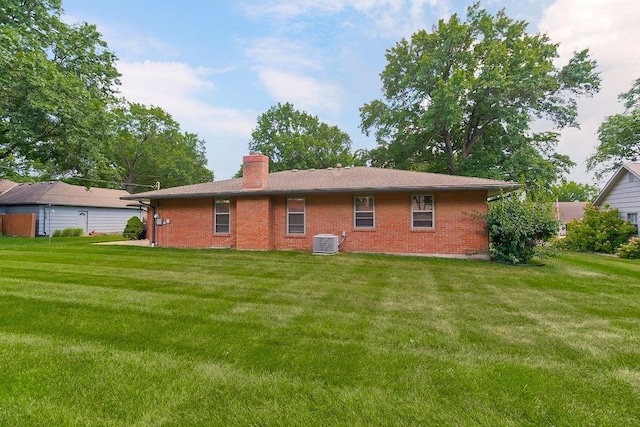 7718 W 100th St, Overland Park, KS 66212 - back of property featuring brick siding, a chimney, and a yard