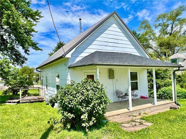 14364 N Bay St, Mercer, MO 64661 - back of house featuring a yard, covered porch, and a shingled roof