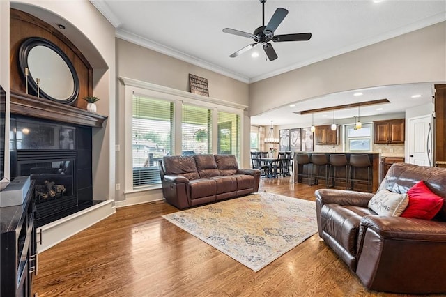 18501 S Butternut St W, Gardner, KS 66030 - living area with crown molding, wood finished floors, ceiling fan, a tiled fireplace, and recessed lighting