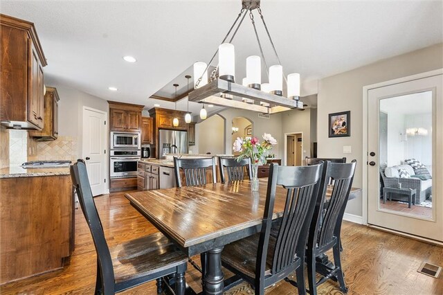 18501 S Butternut St W, Gardner, KS 66030 - dining area with wood finished floors, arched walkways, and recessed lighting