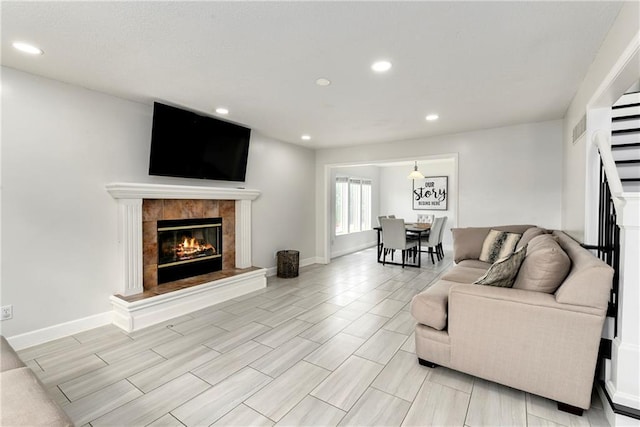 14733 Hickory Dr, Bonner Springs, KS 66012 - living area featuring a tiled fireplace, recessed lighting, and stairway