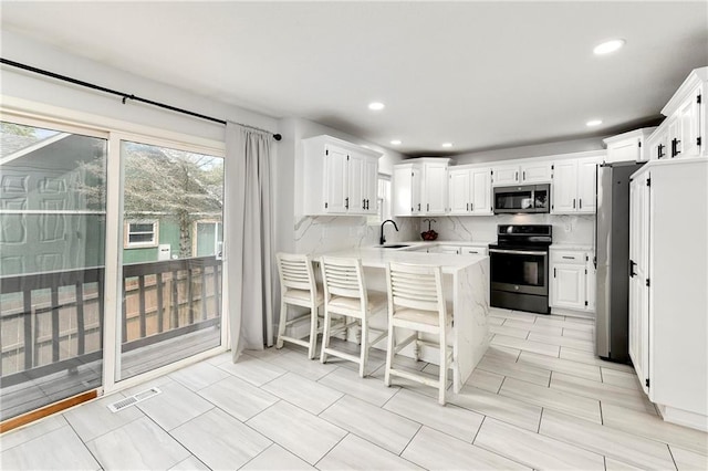 14733 Hickory Dr, Bonner Springs, KS 66012 - kitchen featuring stainless steel appliances, a peninsula, light countertops, decorative backsplash, and recessed lighting