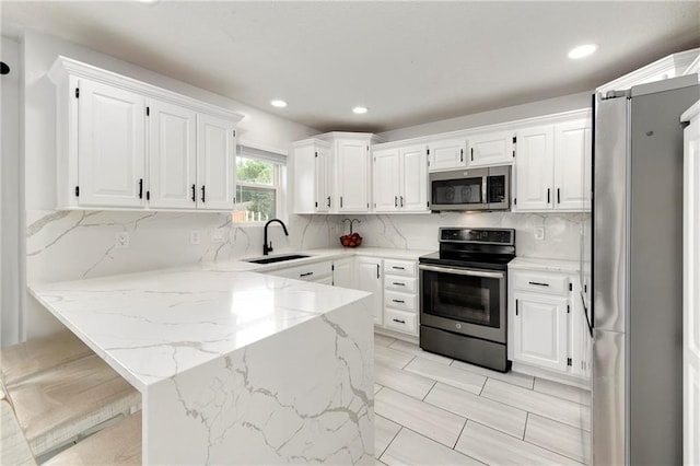 14733 Hickory Dr, Bonner Springs, KS 66012 - kitchen with appliances with stainless steel finishes, a peninsula, white cabinets, light stone countertops, and tasteful backsplash