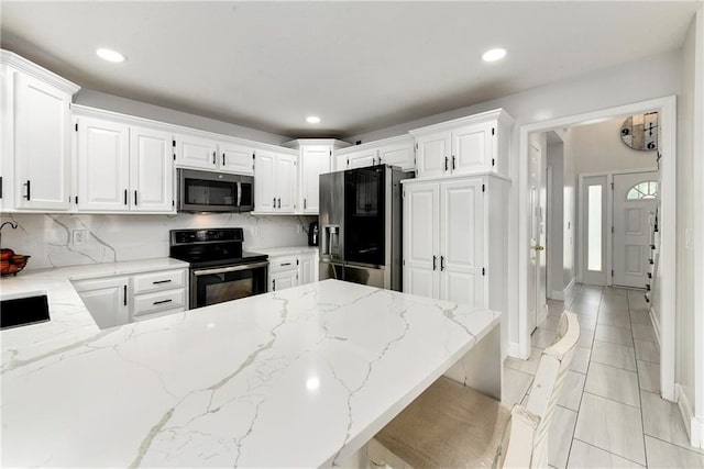 14733 Hickory Dr, Bonner Springs, KS 66012 - kitchen with stainless steel microwave, fridge with ice dispenser, black / electric stove, light stone counters, and recessed lighting
