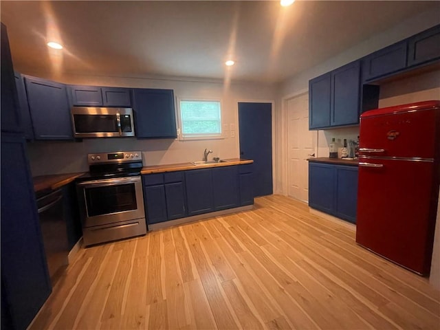 1807 Dodds Camp Rd, Climax Springs, MO 65324 - kitchen featuring stainless steel appliances, light wood-style floors, blue cabinets, and recessed lighting