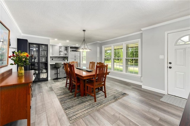 1410 Vilas St, Leavenworth, KS 66048 - dining room with wood finished floors, a textured ceiling, and ornamental molding