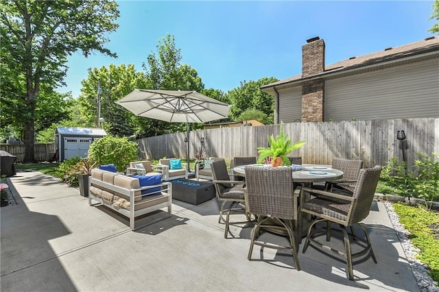 1410 Vilas St, Leavenworth, KS 66048 - fenced backyard with a patio, an outdoor living space with a fire pit, outdoor dining area, and a storage shed