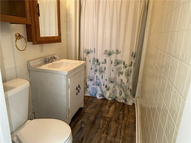 310 E 3rd Ave, Garnett, KS 66032 - bathroom featuring tile walls, wood finished floors, vanity, and curtained shower