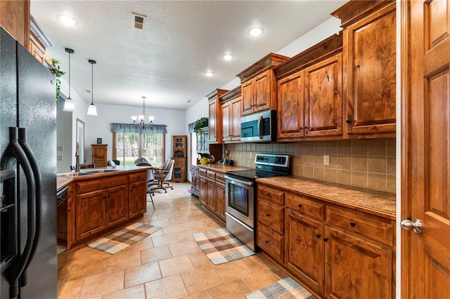 903 Howenstein St, Cameron, MO 64429 - kitchen featuring appliances with stainless steel finishes, backsplash, a chandelier, brown cabinetry, and pendant lighting