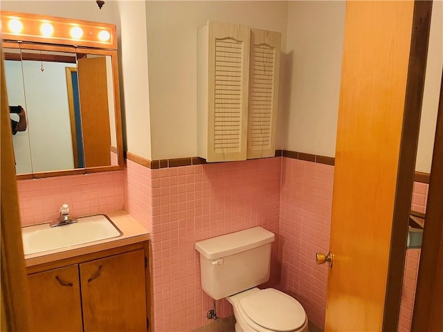 506 1st Ter, Lansing, KS 66043 - half bathroom with tile walls, vanity, and wainscoting