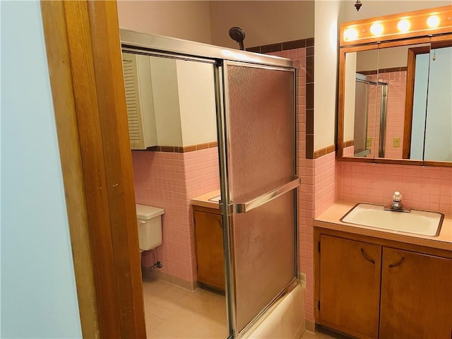 506 1st Ter, Lansing, KS 66043 - full bathroom with tile walls, vanity, tile patterned flooring, wainscoting, and enclosed tub / shower combo