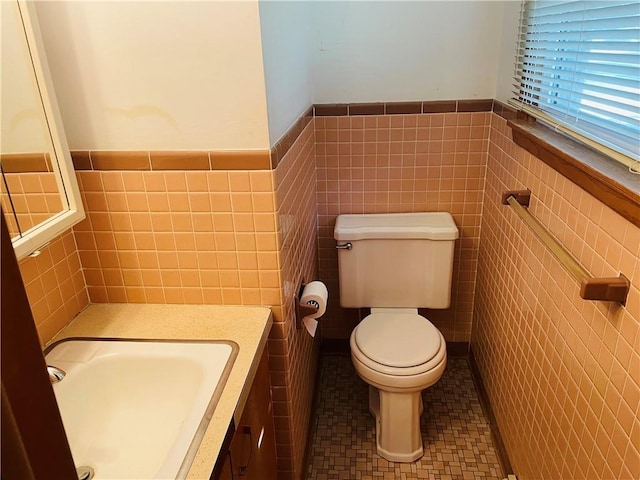 506 1st Ter, Lansing, KS 66043 - half bath featuring a wainscoted wall, tile walls, and vanity