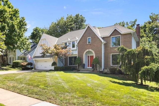 12312 Nieman Rd, Overland Park, KS 66213 - view of front of property featuring a chimney, driveway, a front lawn, brick siding, and an attached garage