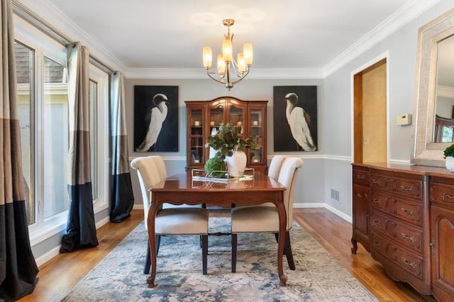 12312 Nieman Rd, Overland Park, KS 66213 - dining room with a chandelier, light wood-style floors, and crown molding