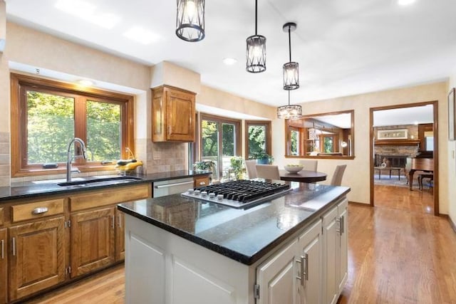 12312 Nieman Rd, Overland Park, KS 66213 - kitchen with a kitchen island, light wood-type flooring, backsplash, stainless steel appliances, and hanging light fixtures