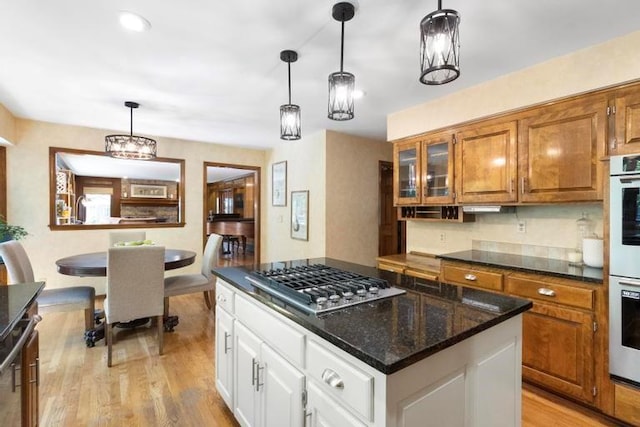 12312 Nieman Rd, Overland Park, KS 66213 - kitchen featuring stainless steel gas stovetop, brown cabinetry, light wood-style flooring, a kitchen island, and white cabinetry