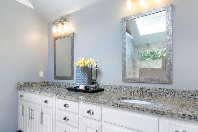 12312 Nieman Rd, Overland Park, KS 66213 - bathroom with double vanity, lofted ceiling, a tile shower, and a skylight