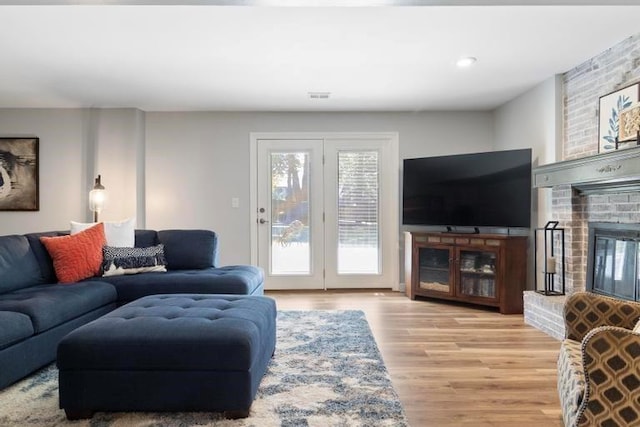 12312 Nieman Rd, Overland Park, KS 66213 - living room featuring light wood-style floors and a brick fireplace