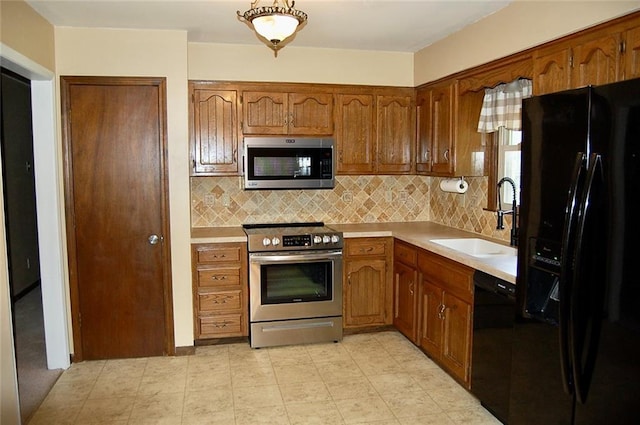 407 Hithergreen Dr, Lansing, KS 66043 - kitchen with black appliances, light countertops, decorative backsplash, and brown cabinetry