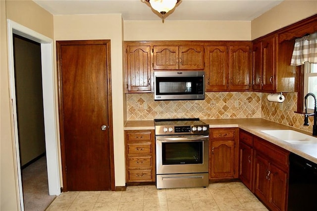 407 Hithergreen Dr, Lansing, KS 66043 - kitchen featuring appliances with stainless steel finishes, backsplash, light countertops, and brown cabinetry