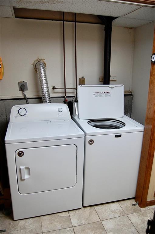 407 Hithergreen Dr, Lansing, KS 66043 - washroom with washer and clothes dryer and light tile patterned flooring